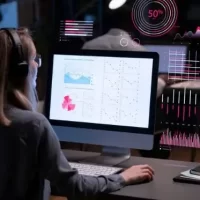 Pessoa analisando gráficos e dados em uma tela de computador com gráficos interativos, representando análise de dados em ambiente de trabalho moderno.