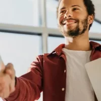 Colegas de trabalho frente a frente apertando as mãos