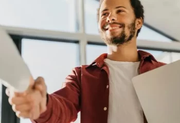 Colegas de trabalho frente a frente apertando as m&atilde;os
