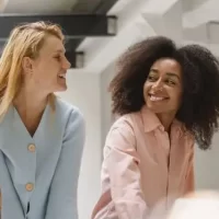 Grupo de jovens sorrindo e interagindo em um ambiente moderno.
