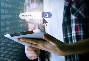 Pessoa segurando um tablet com uma ilustração de uma busca na internet destacada na tela, simbolizando pesquisa online e tecnologia, com fundo digital
